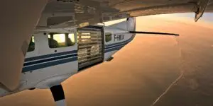 Cessna 208 en vol survolant la côte de lumière